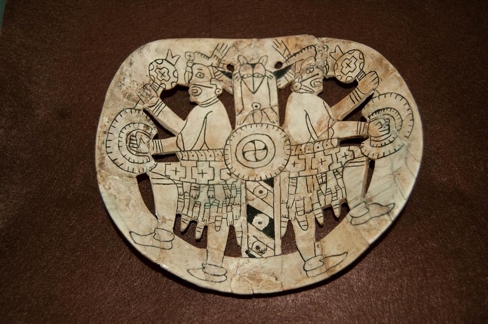 Engraved gorget with two dancing figures holding rattles and drums