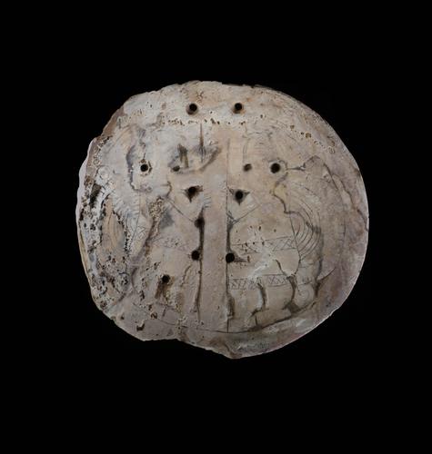 Engraved gorget with two dancing figures surrounding a pole