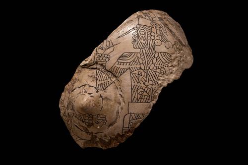 Engraved shell of figure with tattoos and earspools